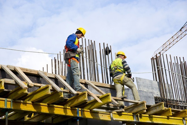 deux travailleurs indépendants réalisant un coffrage sur un chantier