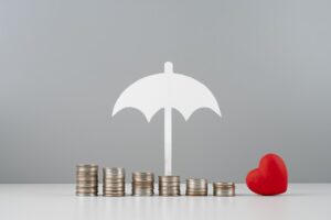 Parapluie protégeant des pièces de monnaie, symbolisant la protection financière et les assurances pour les professionnels indépendants.